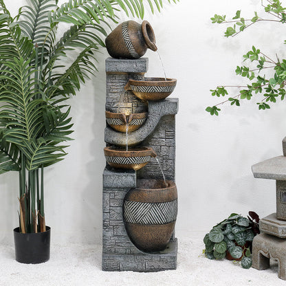 Resin Carved Clay Urn Outdoor Water Fountain 42 Inch shown with water flowing into patterned bowls beside potted plants.
