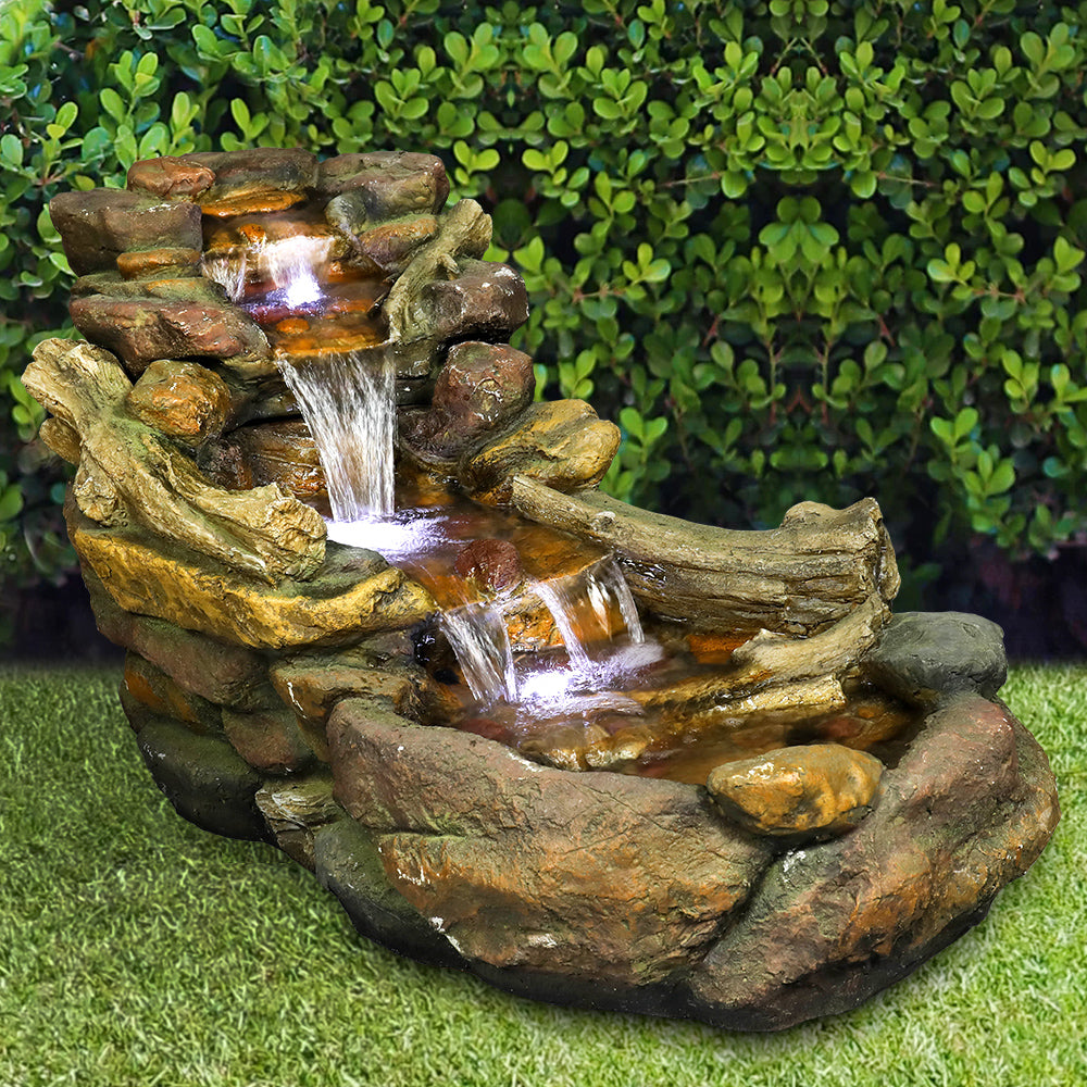 Resin Driftwood Creek Horizontal Outdoor Fountain 39 in with water spilling over rock tiers on green lawn.