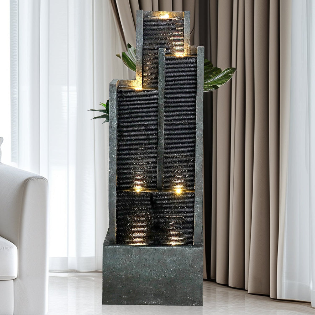 Resin Ribbed Slate Outdoor Water Fountain Quiet 50 in stands indoors beside a white chair, curtains, and a leafy plant.