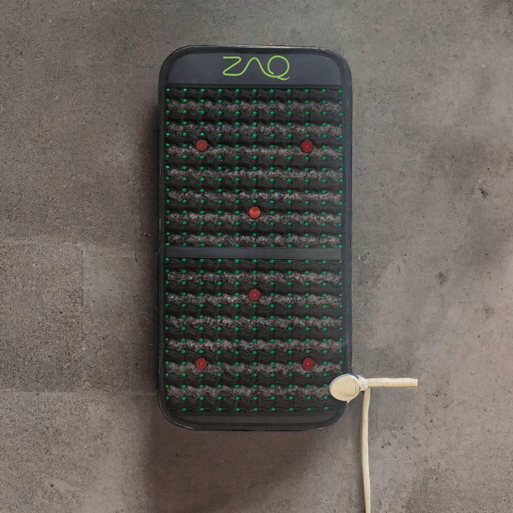 Infrared PEMF Travel Mat viewed from above on a gray floor, with its cord extending to the side.