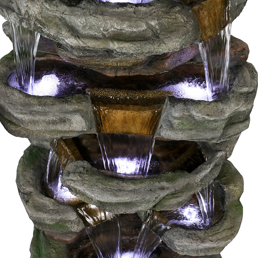 Detail of Resin Stepped Shale Outdoor Rock Fountain with water cascading through several illuminated rock basins.