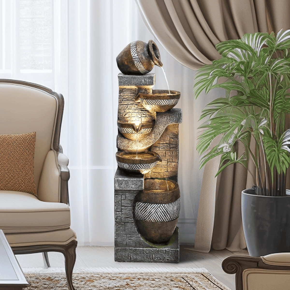 Resin Carved Clay Urn Outdoor Water Fountain 42 Inch stands in a sitting room beside an armchair and potted palm.
