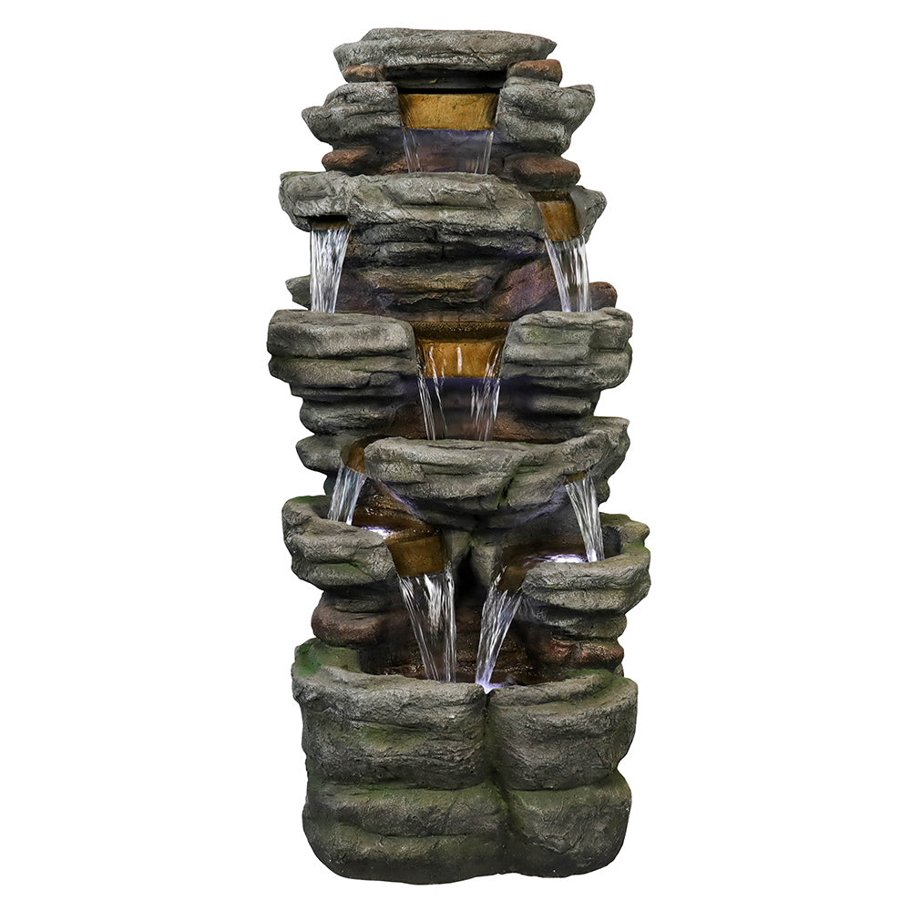 Resin Stepped Shale Outdoor Rock Fountain shown alone, with water flowing down its stacked rocky tiers.