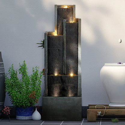 Resin Ribbed Slate Outdoor Water Fountain Quiet 50 in displayed on a tiled patio beside potted plants and a white planter.