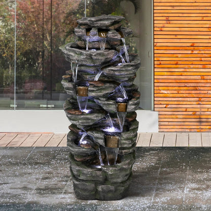 Resin Jagged Shale Outdoor Waterfall Fountain 13 Streams stands beside a modern wood-sided building on wet paving.
