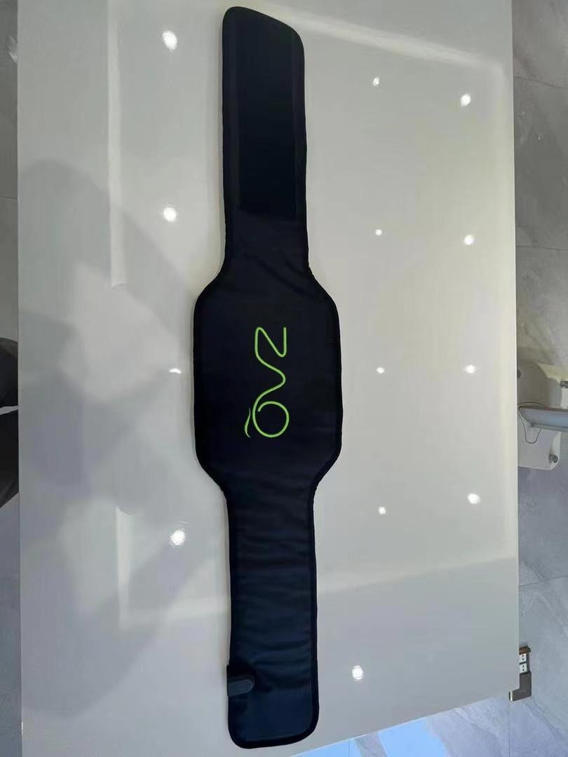 REVA Multifunctional Infrared Heat belt lies vertically on a glossy white surface, showing its plain black side.