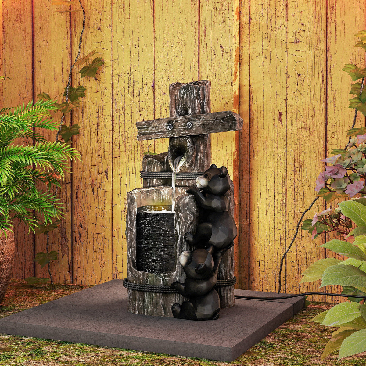 Resin Bear Fountain Two Cubs on Timber Post on a garden slab against a wooden fence, shown straight on.