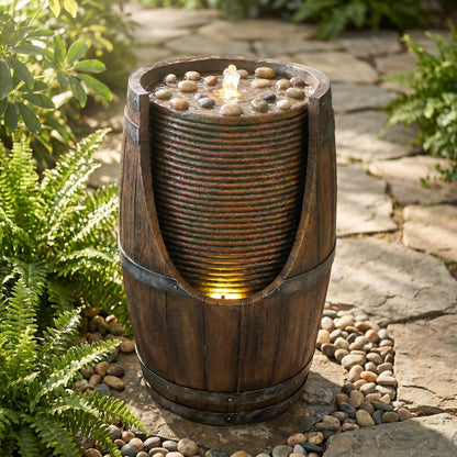 Resin Rustic Barrel Outdoor Water Fountain 24 Inch LED in copper, topped with water and pebbles beside a garden path.