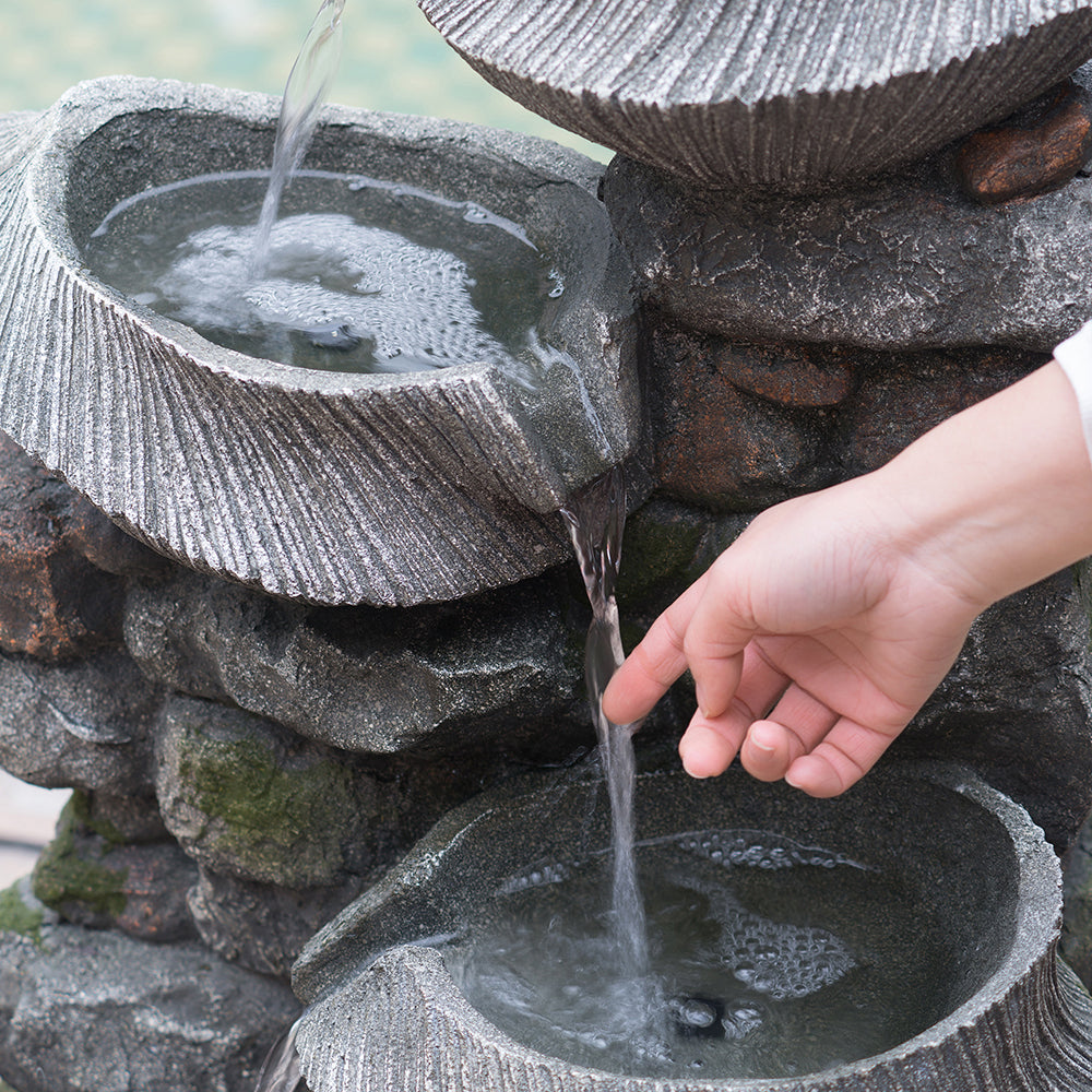 Person touching water on the Resin Fluted Basin Tiered Outdoor Water Fountain 650 GPH.