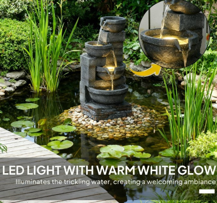 Resin Offset Bowl Cascading Outdoor Water Fountain glows warmly beside a pond, with a close-up inset of lit water.
