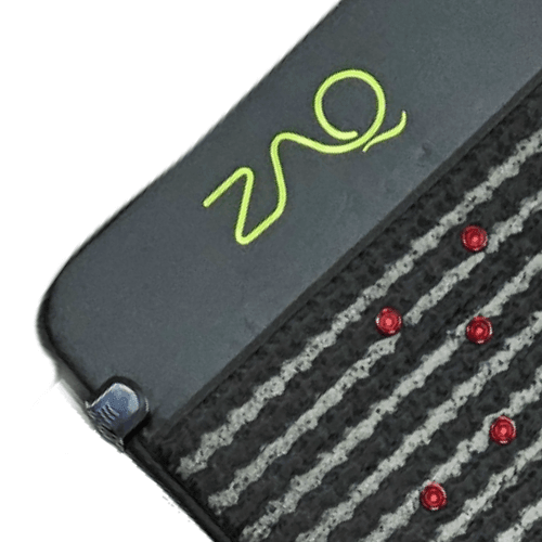 Close-up of the Infrared PEMF Mat showing its lime logo, a corner clasp, textured stripes, and red dots.