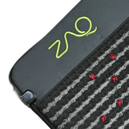 Close-up of the Infrared PEMF Mat showing its lime logo, a corner clasp, textured stripes, and red dots.