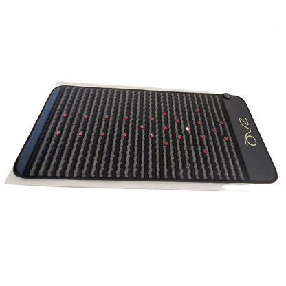 Infrared PEMF Mat shown at an angle on a white background, revealing its striped surface and red dots.